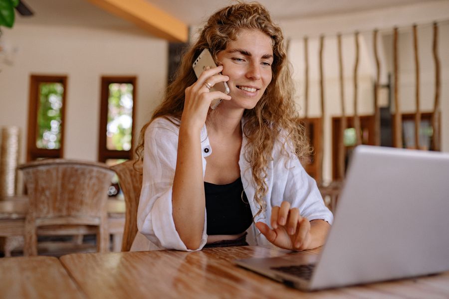 A woman on the phone at her laptop.